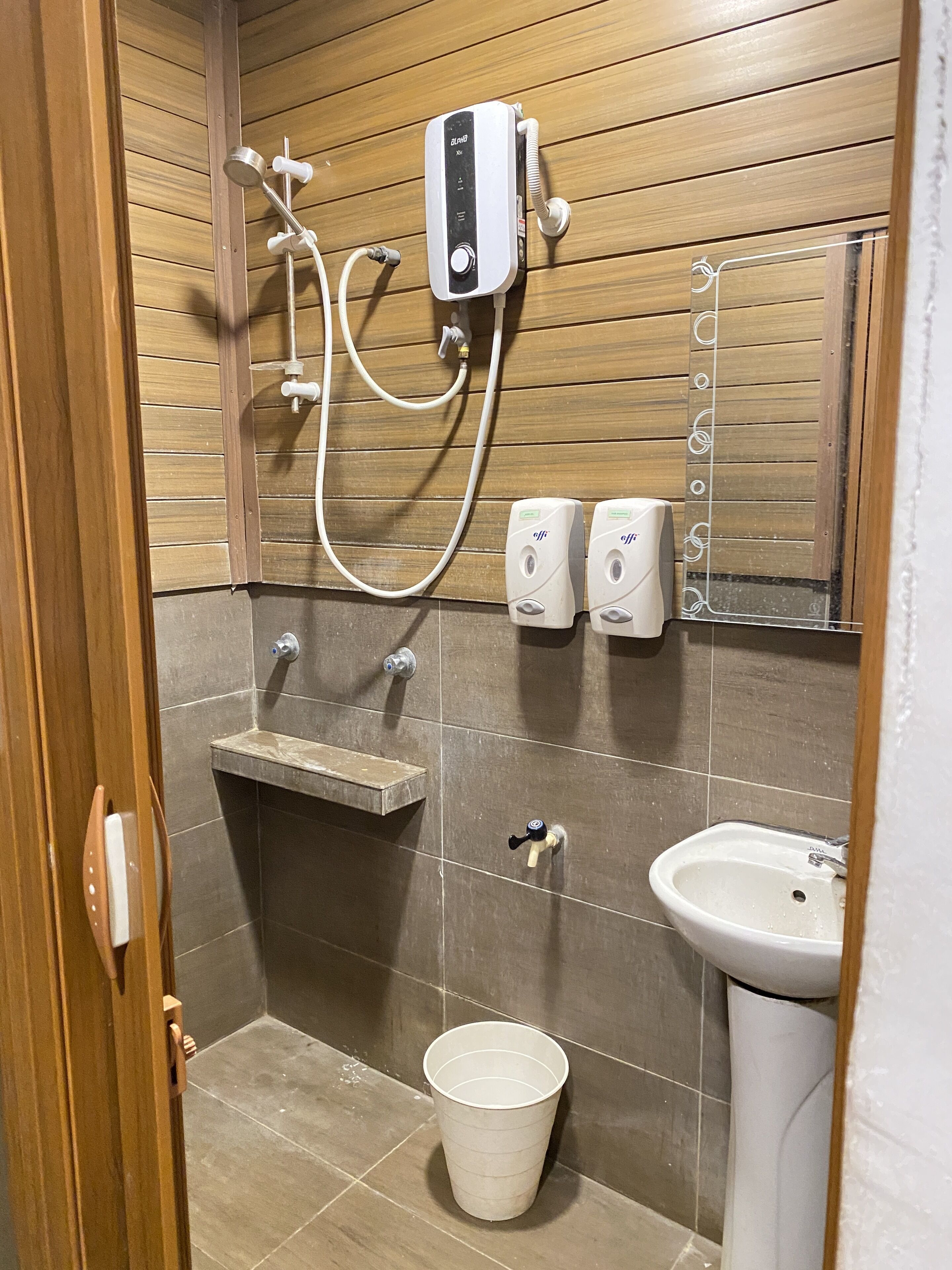 Een badkamer met een douche, wastafel en toilet.