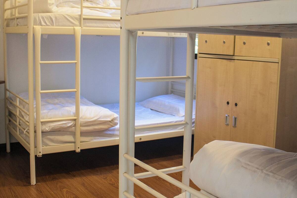 Lits superposés avec plancher en bois et armoire en bois.