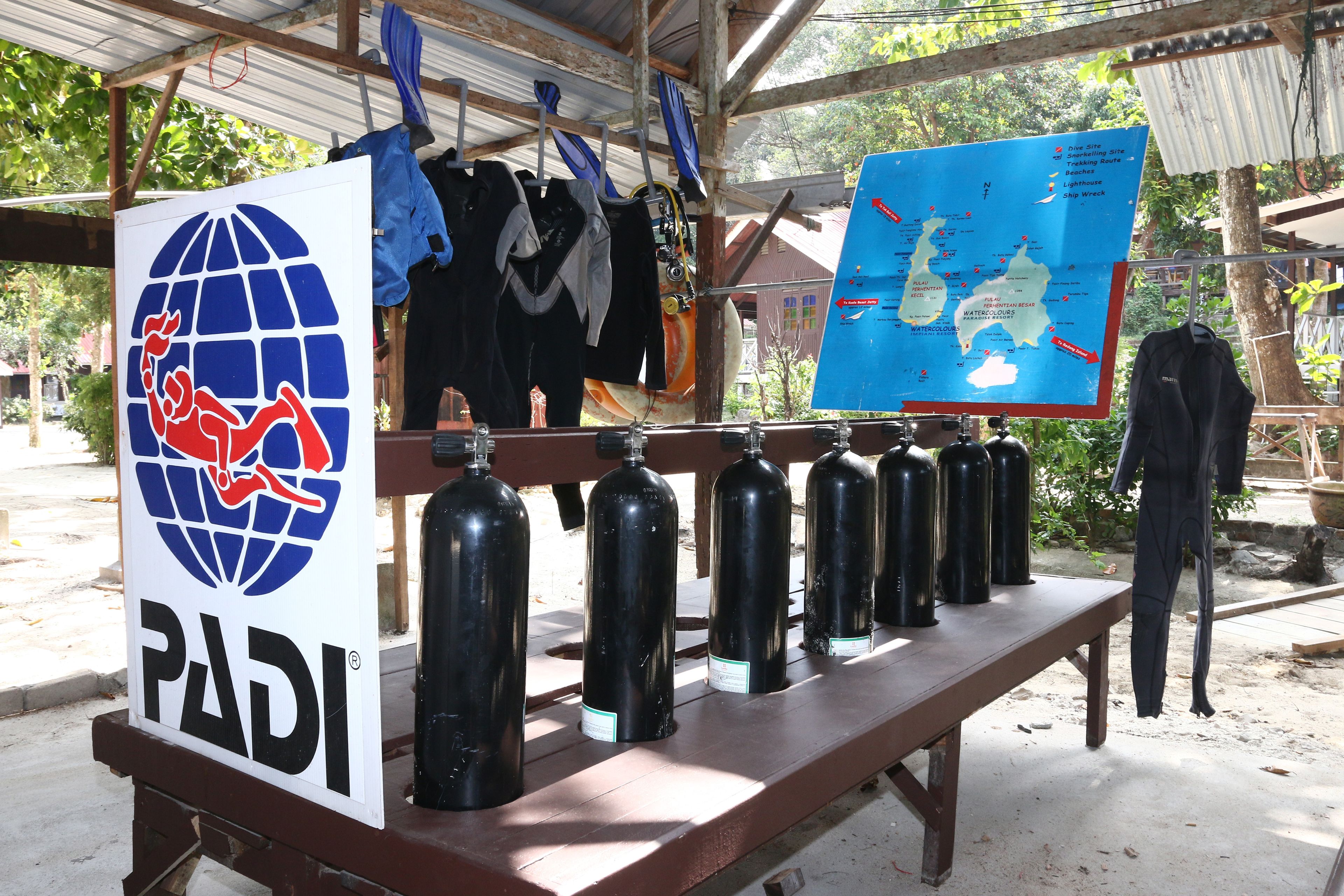 Une table avec du matériel de plongée sous-marine, une carte et le logo PADI.