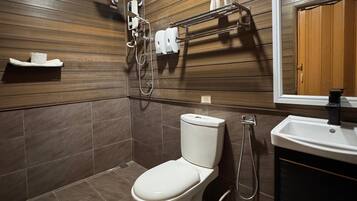 A modern bathroom with a toilet, shower, and sink.