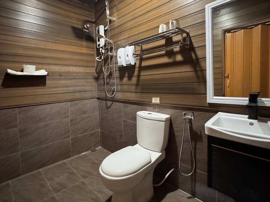 A modern bathroom with a toilet, shower, and sink.