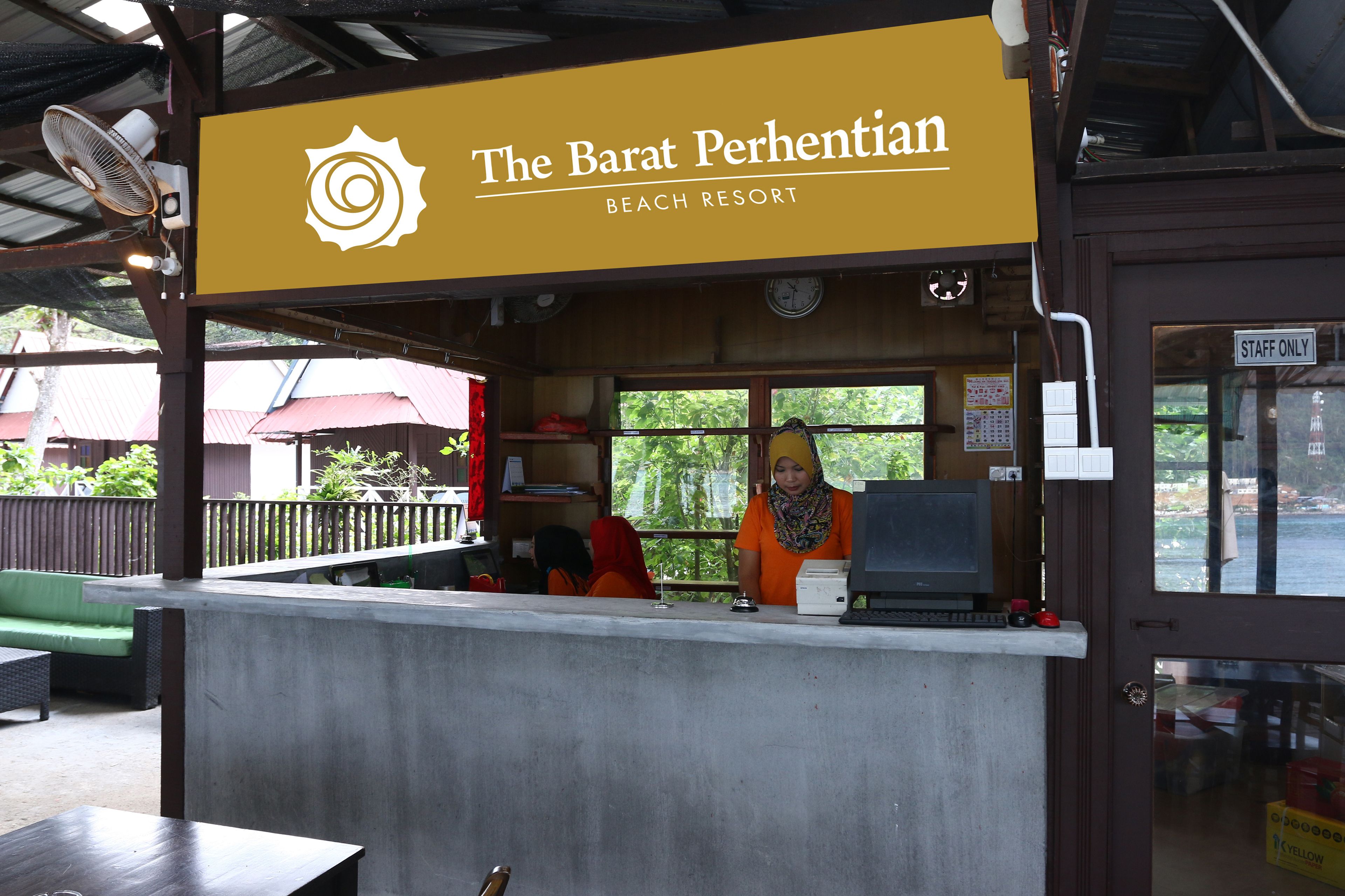 Un complexe hôtelier de bord de mer appelé « The Barat Perhentian », avec un comptoir, une horloge et un panneau indiquant « personnel seulement ».