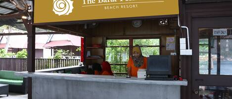 Un complejo turístico en la playa llamado "The Barat Perhentian", con un mostrador, un reloj y un cartel que dice "STAFF ONLY".