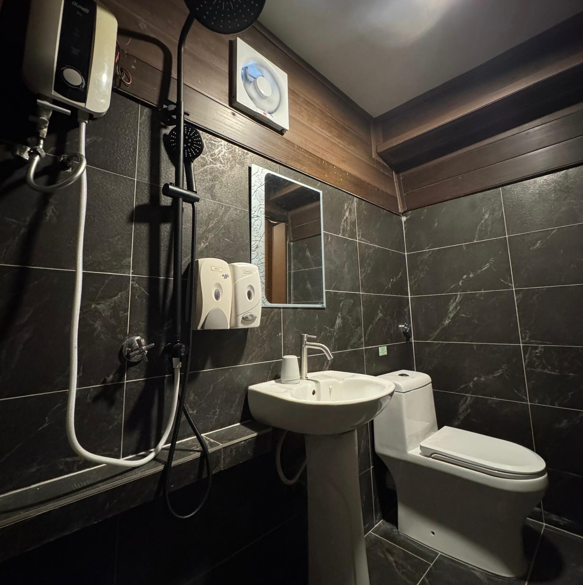 A bathroom with a shower, sink, and toilet.