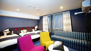 A hotel room with two beds, a sofa, a chair, and a small table. - La'gent Hotel Osaka Bay (Osaka)