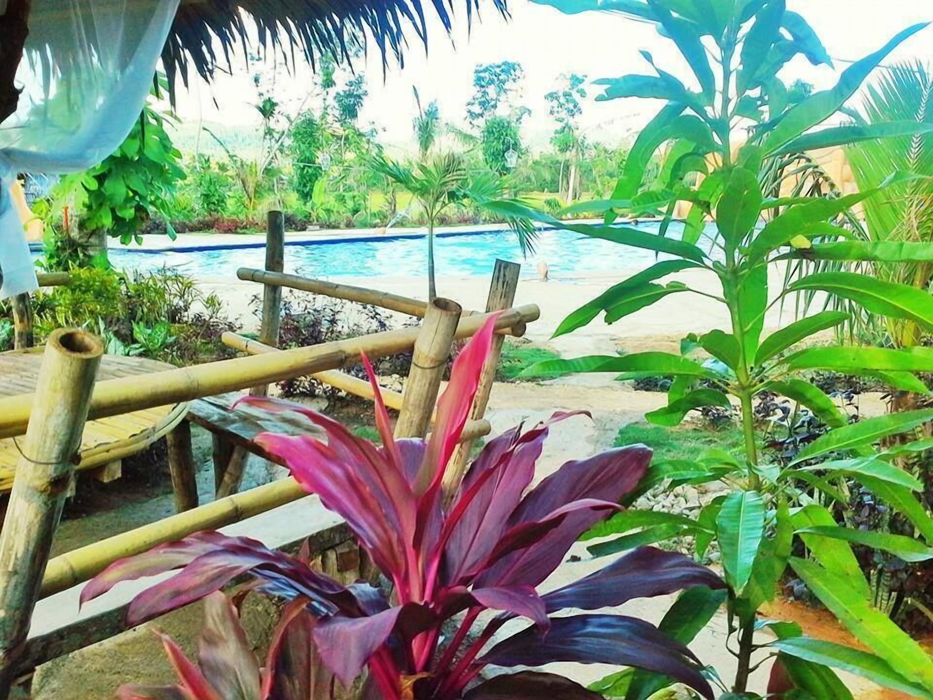 Una piscina al aire libre, camas de piscina gratis, sombrillas