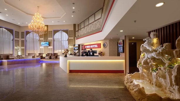 A hotel lobby with a reception desk, seating area, and a decorative waterfall feature. - E-Red Hotel Sdn Bhd (Kuantan)