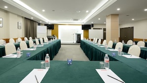A conference room with long tables, chairs, water bottles, and a podium. - E-Red Hotel Sdn Bhd (Kuantan)