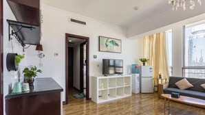 Un salon moderne doté d’un téléviseur à écran plat, d’un canapé, d’une table basse et d’un coin repas avec une table et des chaises.