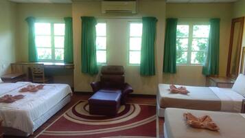 A hotel room with two beds, a sofa, and a desk.