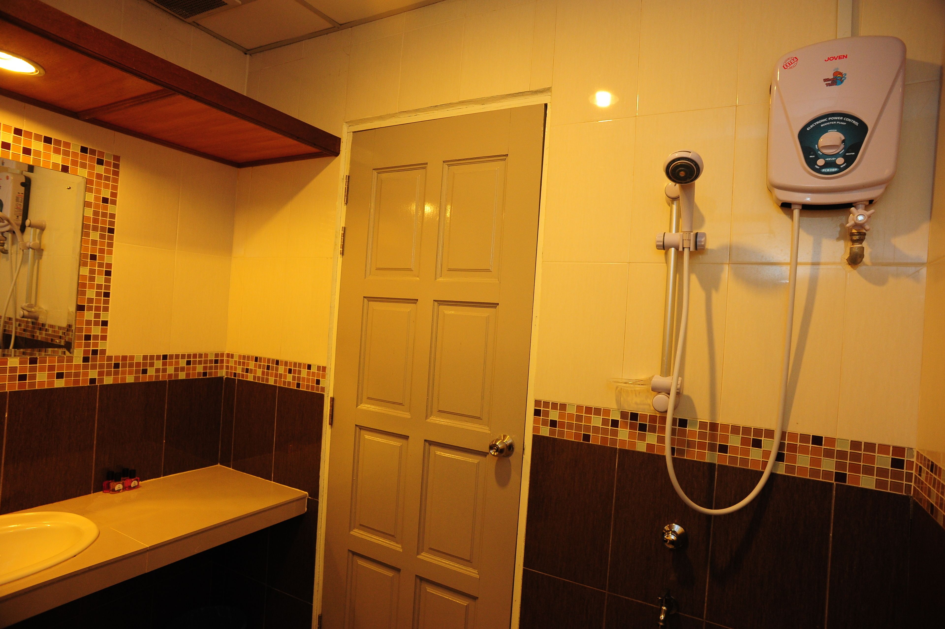A bathroom with a shower, a sink, and a door.