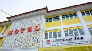 Un hotel con un letrero destacado que dice 'HOTEL' y otro con el nombre 'Arwana Inn'.