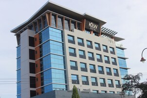 Un hôtel moderne, reconnaissable à son enseigne bien visible portant l’inscription « KEW Hotel ».
