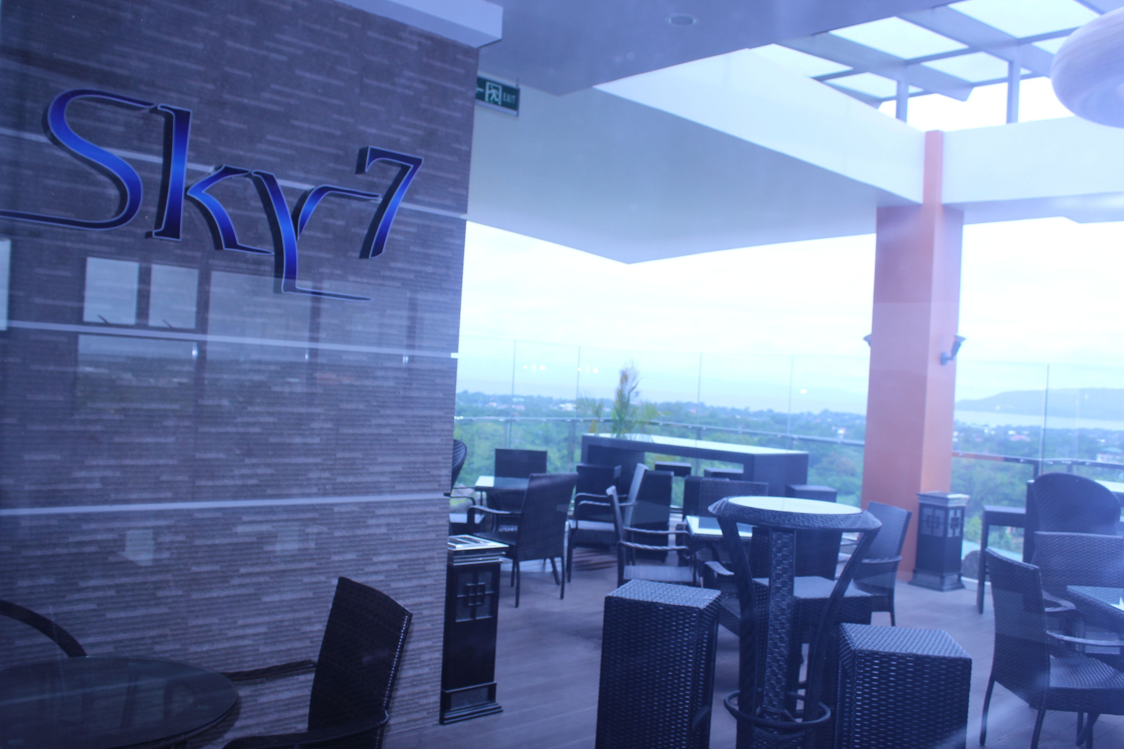 Un bar en la azotea Sky7 con asientos al aire libre y vistas de la ciudad.