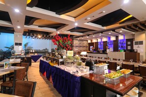 A buffet setup with various food items and a decorative centerpiece. - Kew Hotel (Tagbilaran)