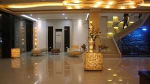 A modern lobby with a central column, a staircase, and a glass railing. - Kew Hotel (Tagbilaran)