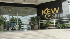 The entrance of Kew Hotel with a modern design, featuring a glass facade and a large potted plant. - Kew Hotel (Tagbilaran)