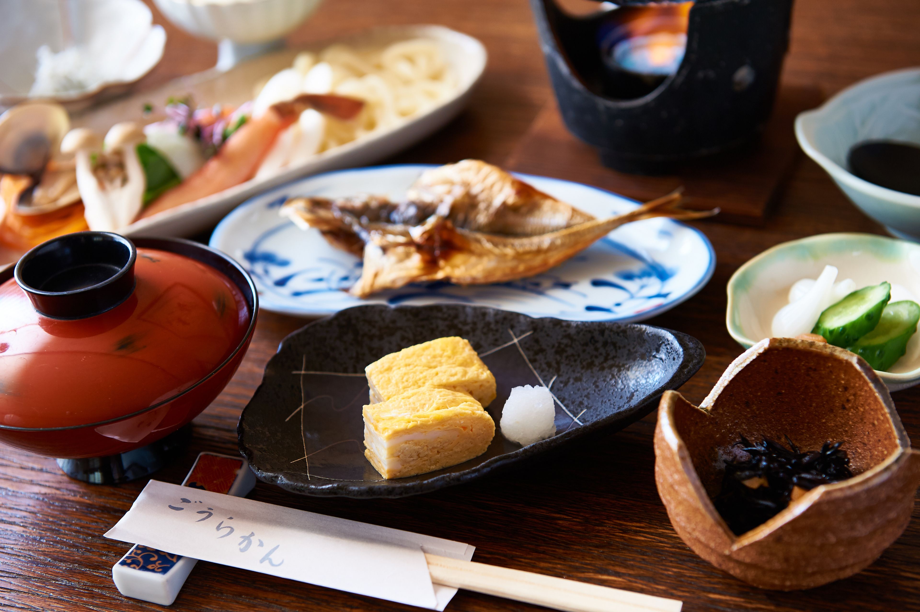 A traditional Japanese meal with various dishes on a wooden table.