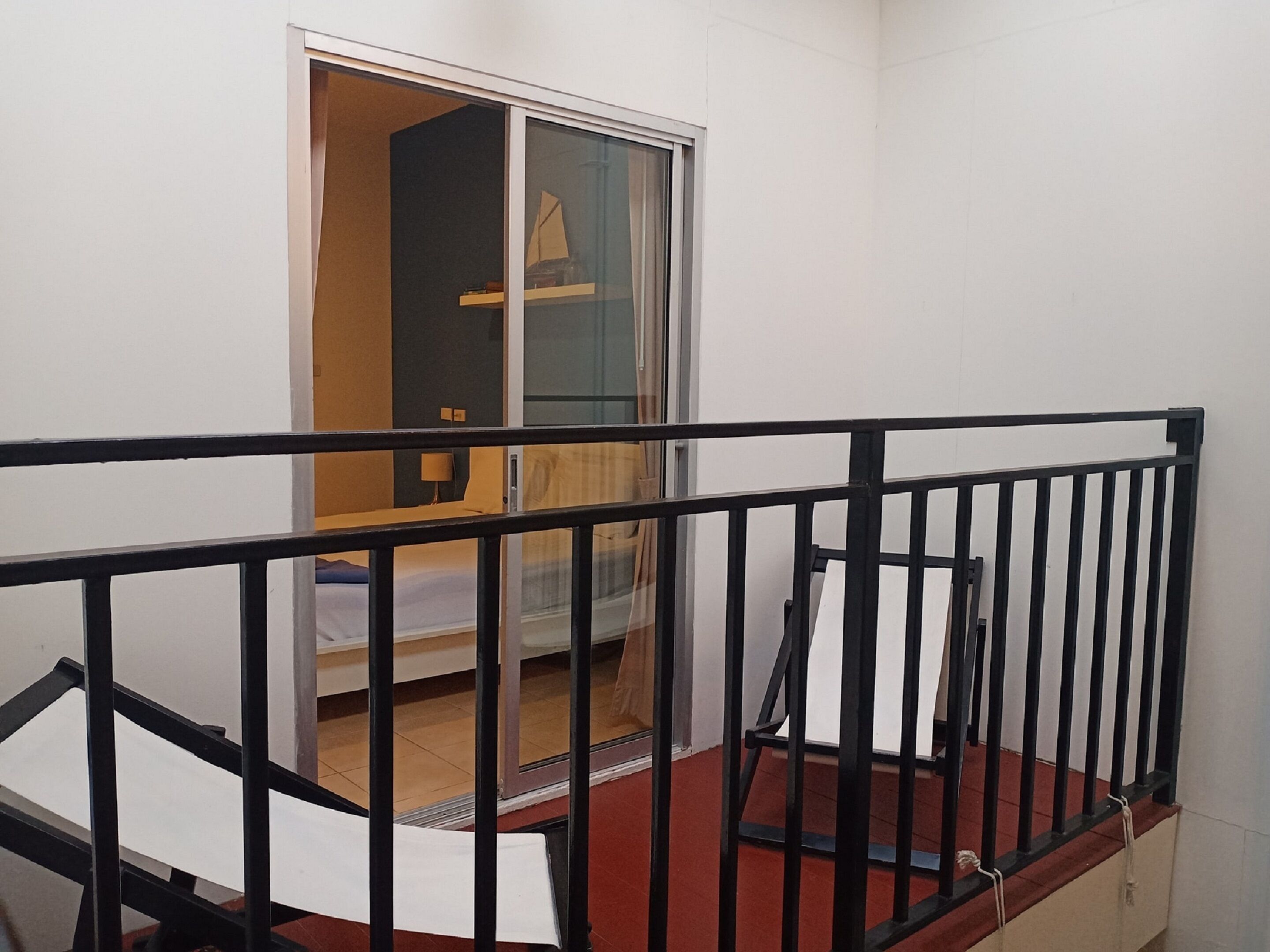A room with a bed, a window, and a red carpet.