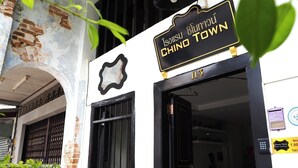 A building entrance with a sign reading "Isolisu Blumau CHINO TOWN" and the number "113". - Chino Town Gallery Alley (Phuket)