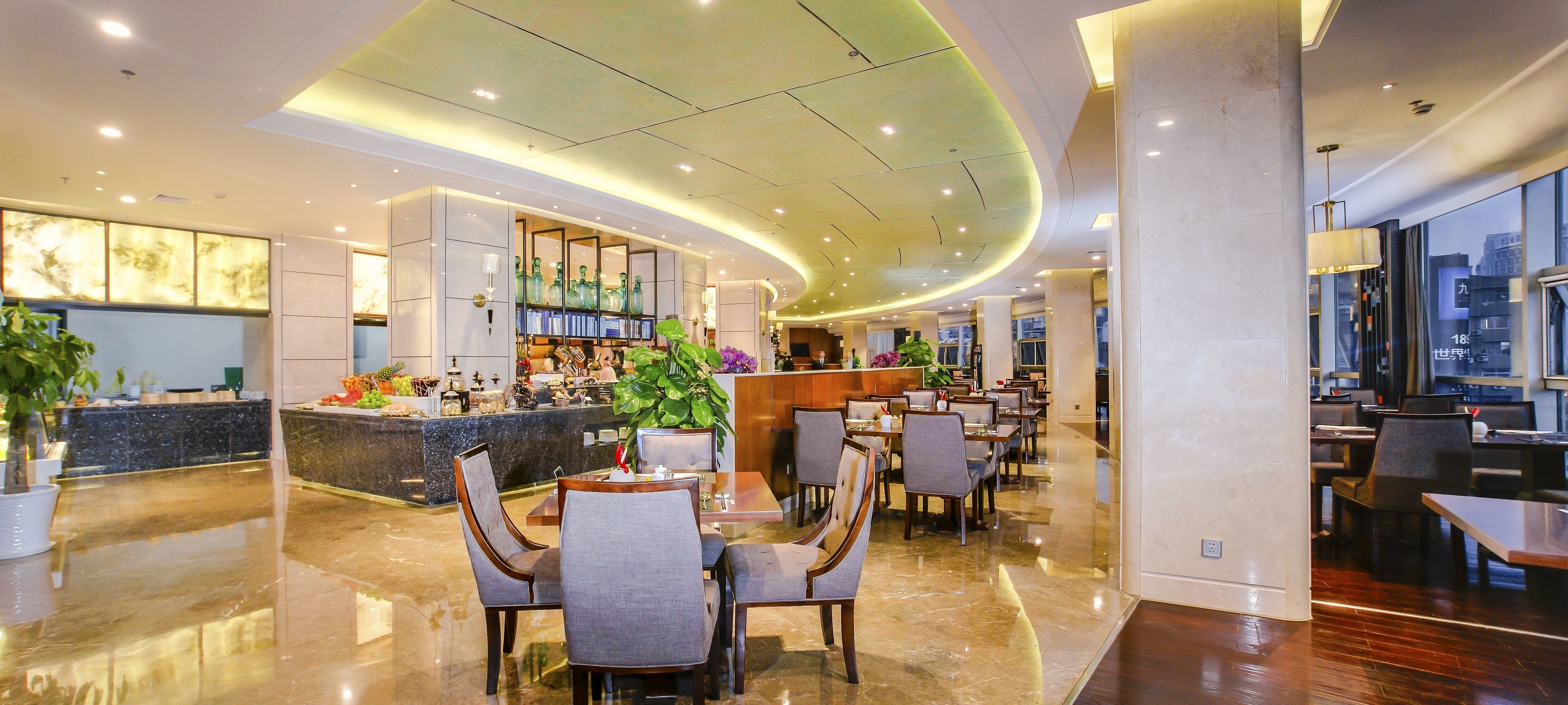 A modern hotel lobby with a bar area, seating arrangements, and a large window offering a city view.