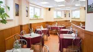 A conference room with tables set for meetings, equipped with chairs and small potted plants. - Voyage Hotel (Minsk)