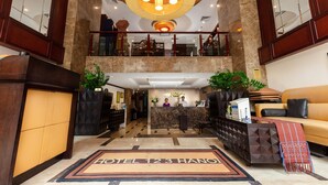 A hotel lobby with a reception desk, a sofa, and a staircase leading to the upper floor. - TK123 Hanoi Hotel (Hanoi)
