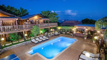 Een buitenzwembad, parasols voor strand/zwembad