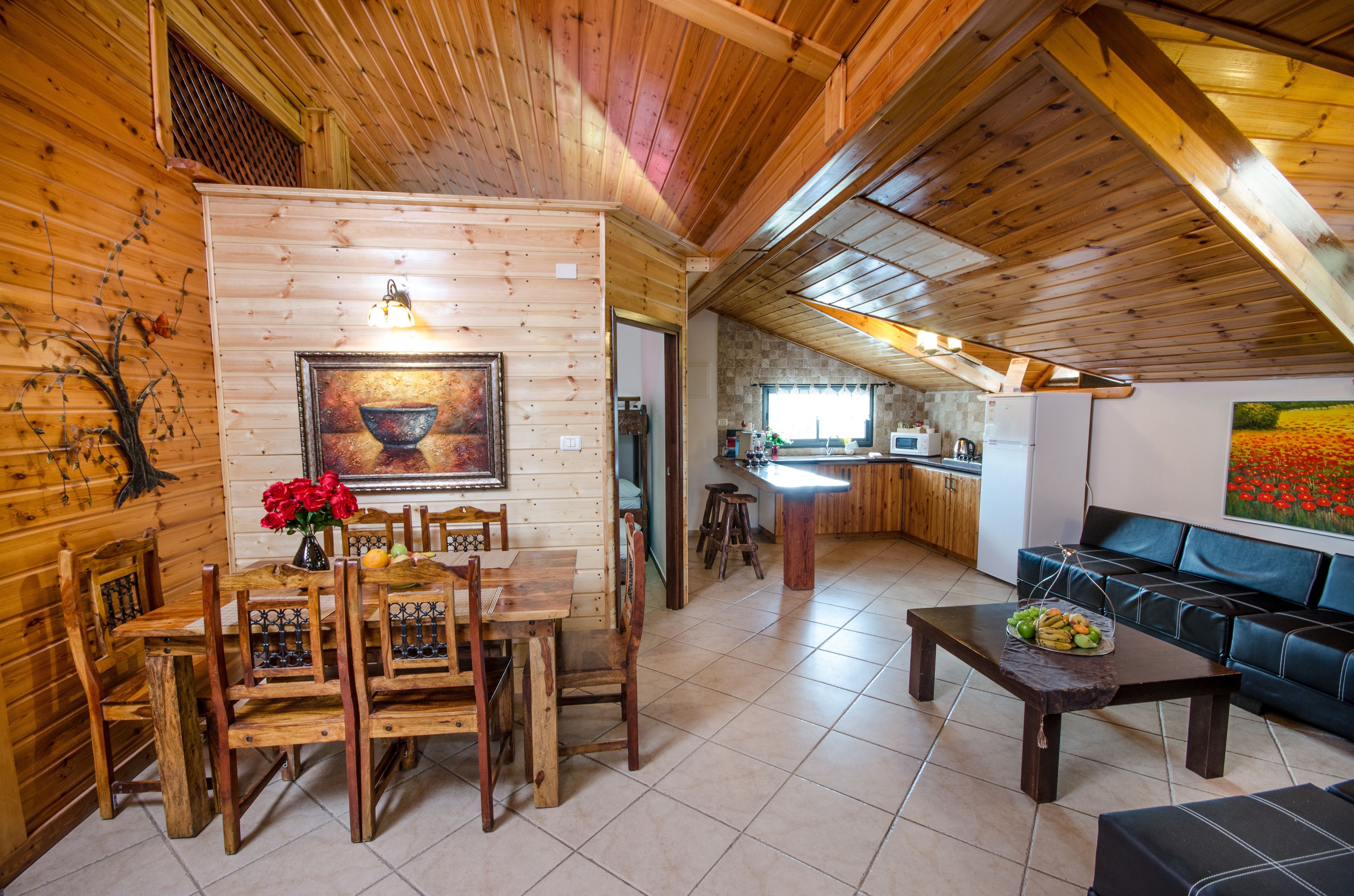 A wooden interior with a dining area, kitchen, and seating space.