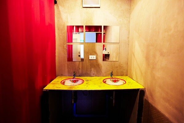 Un baño con dos lavamanos, un espejo y una cortina roja.