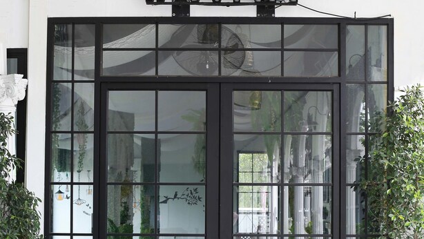 A hotel entrance with a black and white checkered floor, a glass door with a reflection of the interior, and a sign above the door. - Westgate Residence Hotel (Bang Yai)