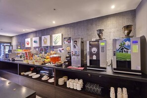 A buffet area with various food items, beverage dispensers, and a coffee machine. - Goldinn Hotel (Taipei)