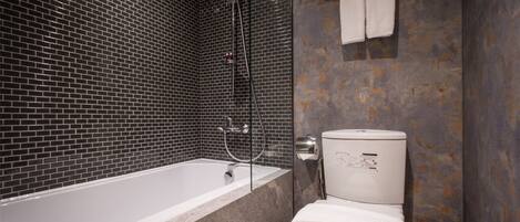 Une salle de bain avec une baignoire, des toilettes et une douche.
