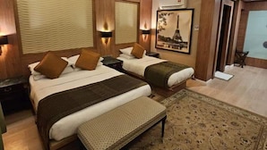A hotel room with two beds, a bench, a patterned rug, and a painting of the Eiffel Tower. - Shari-La Island Resort (Pulau Perhentian Kecil)