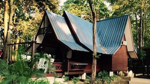 A rustic wooden structure with a sloped roof, surrounded by lush greenery and trees. - Shari-La Island Resort (Pulau Perhentian Kecil)