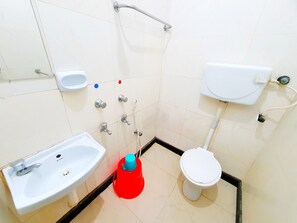 A bathroom with a sink, toilet, and shower. - Hotel Greens (Chennai)
