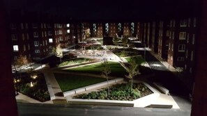 A nighttime view of a residential area with multiple apartment buildings, a well-lit central courtyard, and a small park area. - Maritime Apartments (Barrow-in-Furness)