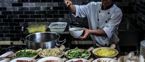 Un chef en una cocina con diversos ingredientes y utensilios de cocina.