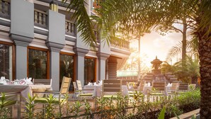 A restaurant with outdoor seating, a fountain, and a traditional pagoda. - J7 Angkor Hotel (Siem Reap)