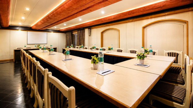 Een vergaderzaal met een lange tafel, stoelen en waterflesjes.