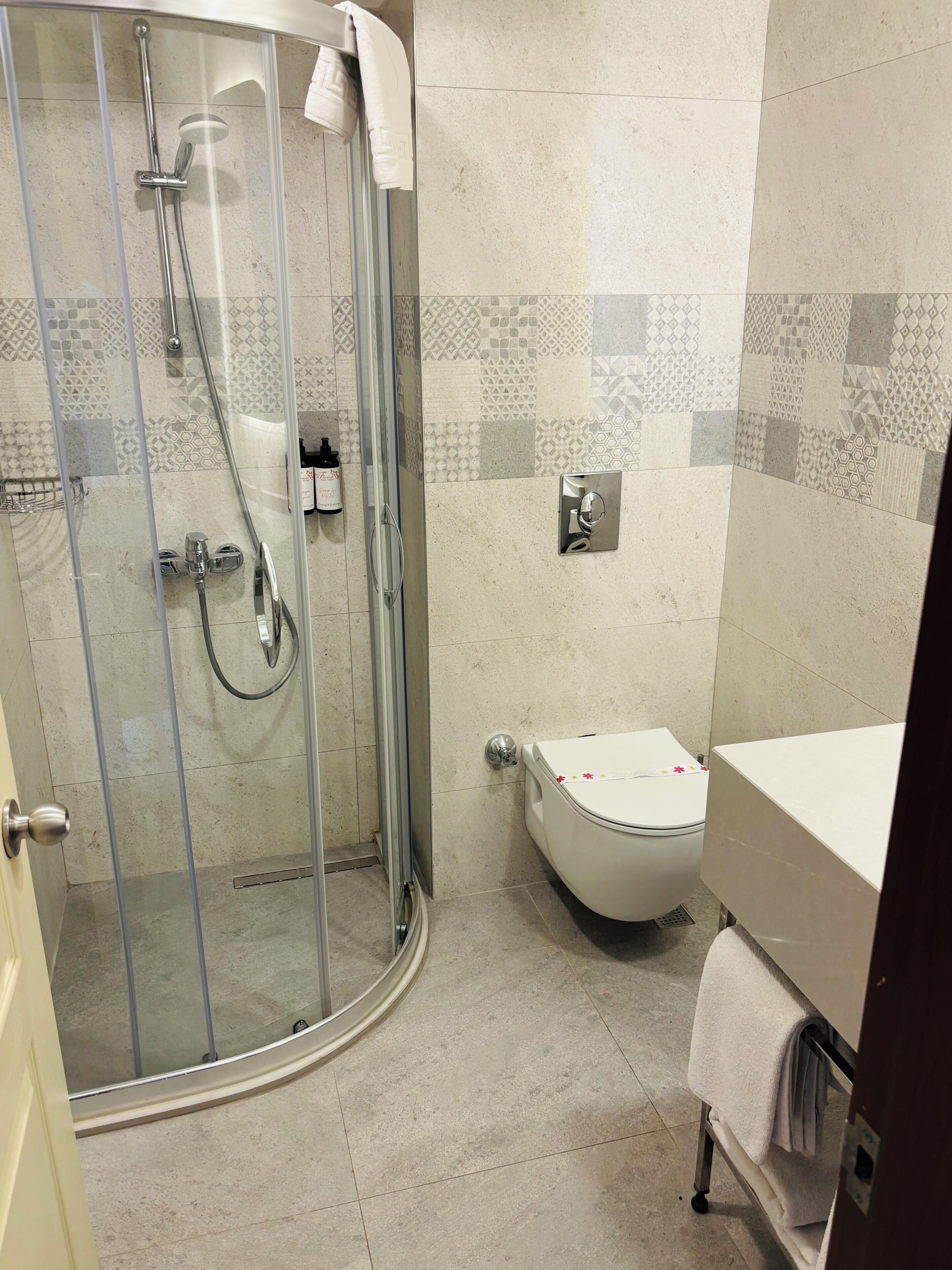 Une salle de bain avec une douche à parois de verre, des toilettes et un lavabo.