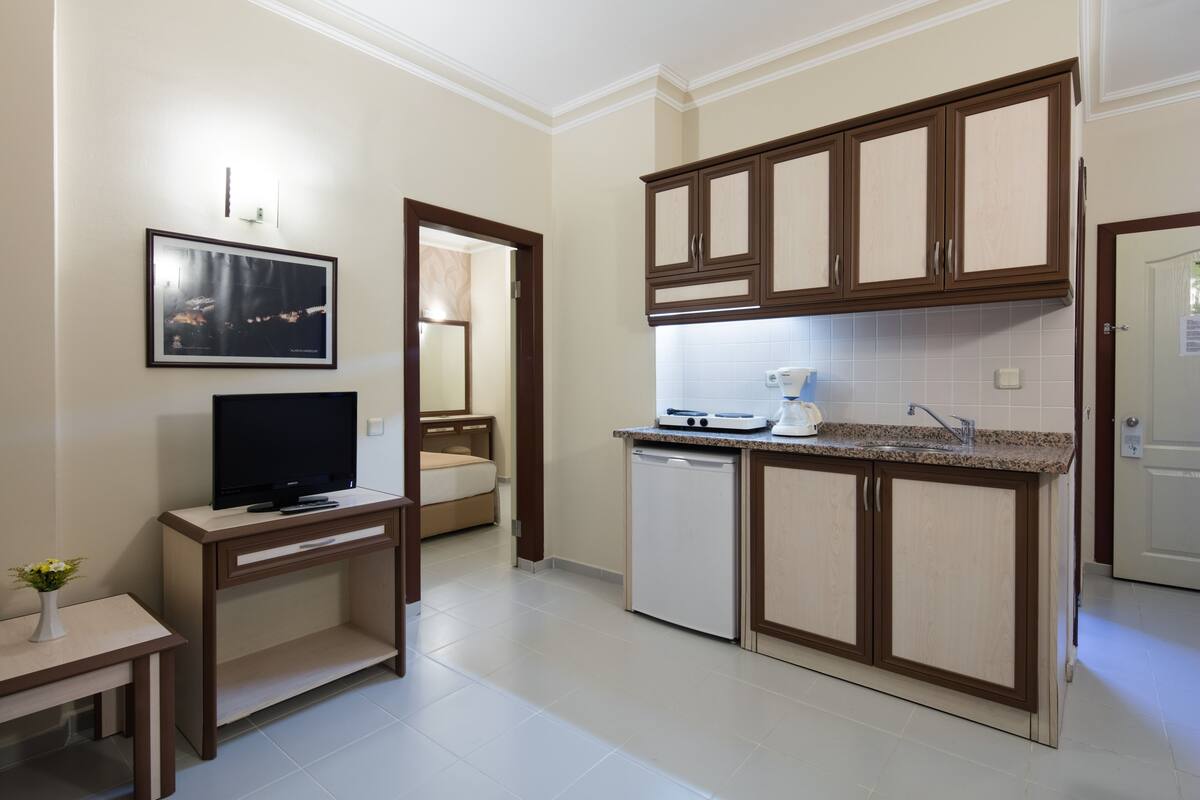 Una cocina compacta con armarios de madera, lavavajillas y una encimera con cafetera.