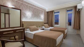 Una habitación de hotel con dos camas, un escritorio, una silla, un espejo y una ventana con cortinas.