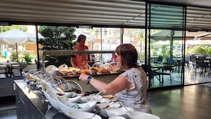 An outdoor buffet setup with various food items and a grill. - May Flower Apart Hotel (Alanya)