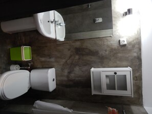 A bathroom with two sinks, a toilet, a cabinet, and a green soap dispenser. - Jacaranda Guesthouse (Maputo)