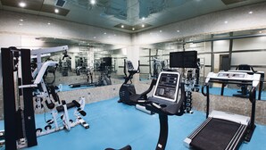 A gym with exercise equipment, mirrors, and a blue floor. - Admiral Hotel Baku (Baku)