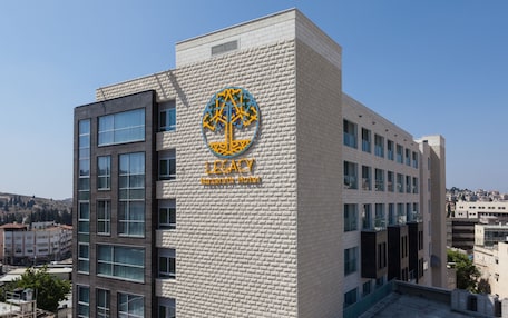 A hotel building with a prominent logo and the name "Legacy" on the facade.