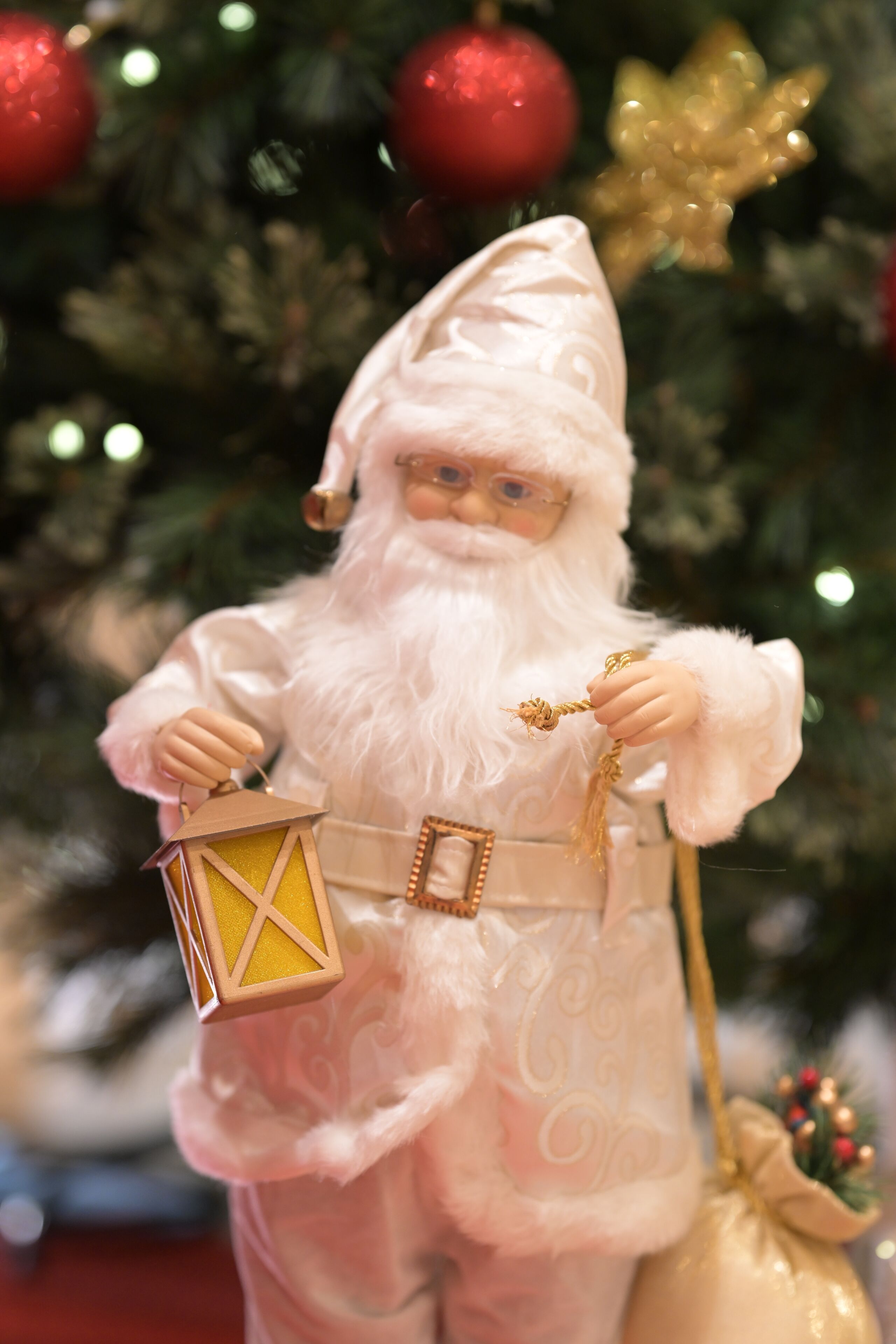 A Christmas ornament of a figure holding a lantern and a sack.