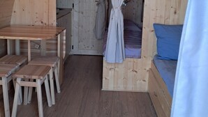 Una habitación de madera con una cama, una mesa y sillas.