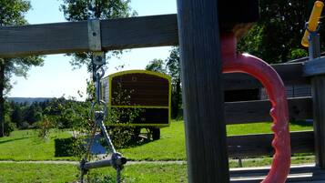 A playground with a wooden swing set and a slide.
